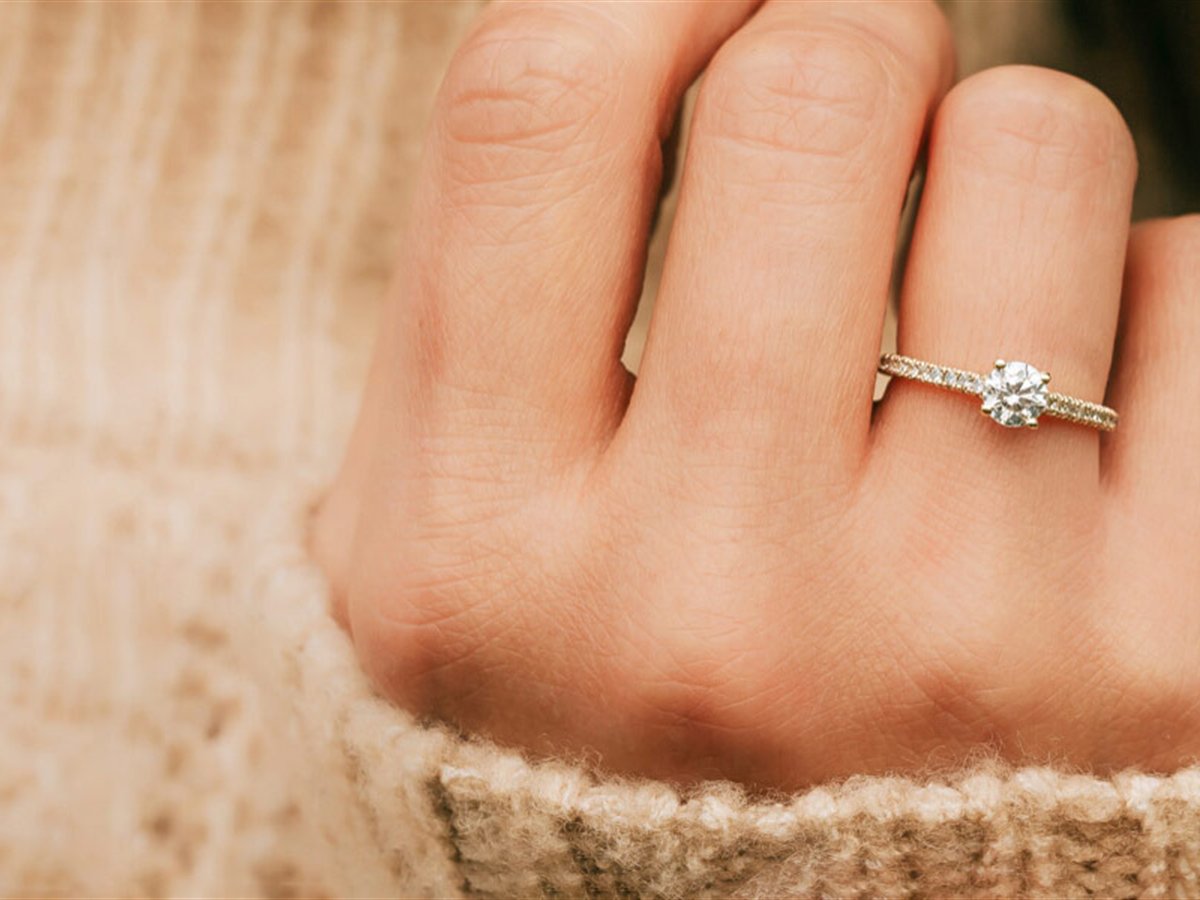 Auronia, diamond solitaire engagement ring modeled by hand